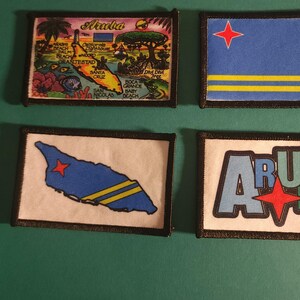 May include: Four Aruba-themed patches with black borders. One patch features a colorful map with text, another displays the Aruba flag with a red star and yellow stripes, a third shows the island's outline, and the last spells "ARUBA" with a red star.