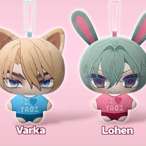 May include: Two plush character charms with ball chains. The left charm has blonde hair, cat ears, and a blue shirt with the text I heart YAOI. The right charm has mint green hair, rabbit ears, and a pink shirt with the text I heart YAOI. Labels read Varka and Lohen.