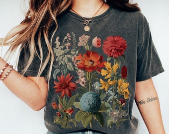 May include: A dark gray t-shirt with a vintage floral print featuring red, orange, yellow, blue, and green flowers. The shirt has a crew neck and short sleeves.