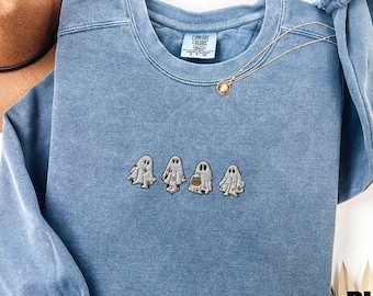 May include: A blue jean sweatshirt with a line of embroidered ghosts holding pumpkins. The sweatshirt has a Comfort Colors tag on the front.