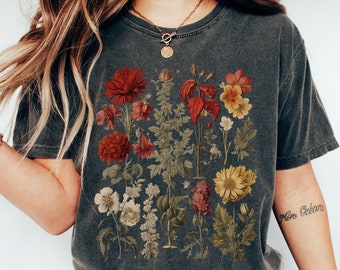 May include: A dark gray t-shirt with a vintage botanical print featuring red, yellow, and white flowers. The shirt has a relaxed fit and a crew neck.