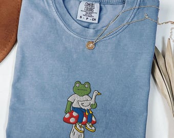 Groda som håller gås på svamp broderad Comfort Colors® T-shirt, rolig groda-tröja, Cottagecore djur-t-shirt, nyckfull naturpresentidé