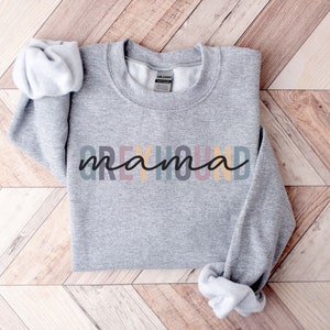 May include: Gray sweatshirt with the text "Greyhound mama" in rainbow colors.