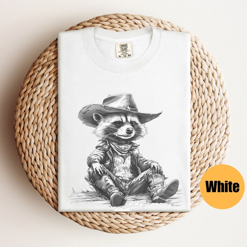 May include: A white t-shirt with a black and white illustration of a raccoon wearing a cowboy hat and a leather jacket. The raccoon is sitting with its legs crossed and is wearing cowboy boots.