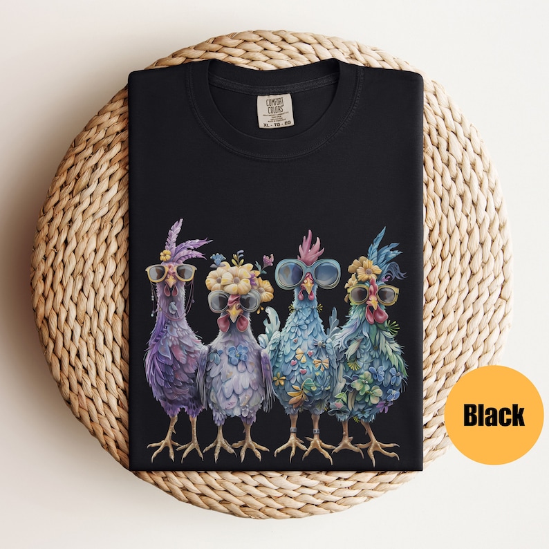 Peut inclure: T-shirt noir avec un motif de quatre poulets portant des lunettes de soleil et des bandeaux floraux. Les poulets sont debout en rang et regardent le spectateur.