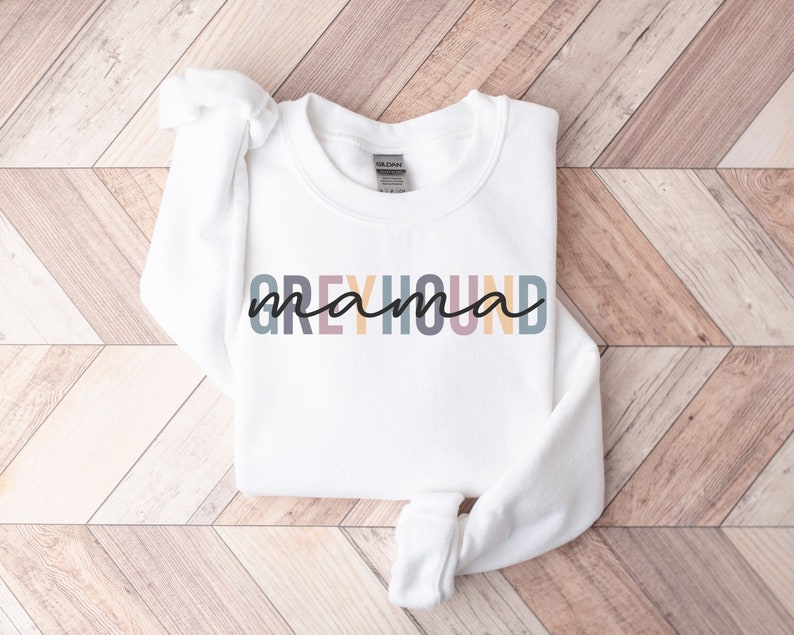 May include: White sweatshirt with the text "Greyhound mama" in rainbow colors.