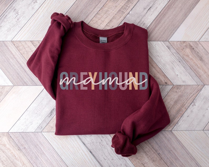 May include: A maroon sweatshirt with the text "Greyhound mama" in colorful letters.