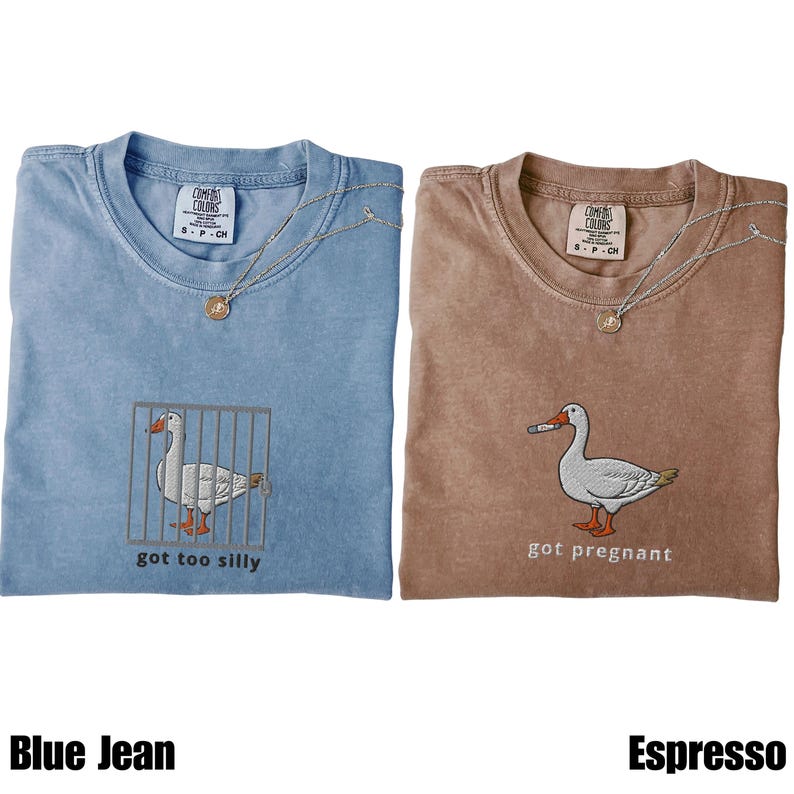 May include: Two Comfort Colors t-shirts, one blue and one brown, each with a unique embroidered goose design. The blue shirt features a goose in a cage with the text "got too silly." The brown shirt shows a goose with a cigarette and the text "got pregnant."