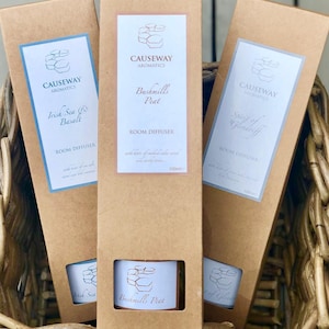 May include: Three brown cardboard boxes with white labels containing room diffusers. The labels feature the Causeway Aromatics logo and the names of the scents: Irish Sea & Basalt, Bushmills Peat, and Spirit of Glenareff. Each box has a 100ml room diffuser inside.