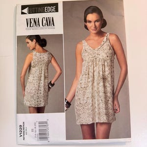 May include: A Vogue Patterns sewing pattern envelope for Vena Cava design V1229, featuring a sleeveless, knee-length dress with a gathered bodice and a light-colored, intricate, repeating pattern. The envelope displays the front and back views.