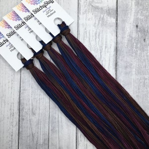 May include: Six skeins of hand-dyed 100% cotton embroidery floss in shades of brown, burgundy, and blue. The floss is labelled "Stitch StitchyStuf" and "Medieval".