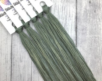 May include: Six skeins of hand-dyed 100% cotton embroidery floss in a sage green color. The skeins are labeled "Stitch Stichy" and "Sage Leaves".