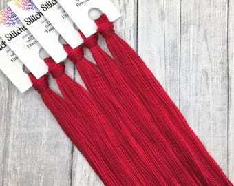 以下が含まれることがあります： 鮮やかな赤色の刺繍糸の束で、「Firecracker」と「Stitchy Stuff」のラベルが付いています。各束は手染めで、100％コットン製で、約7.3メートルの糸が含まれています。糸は束ねられ、白いカードに付けられています。