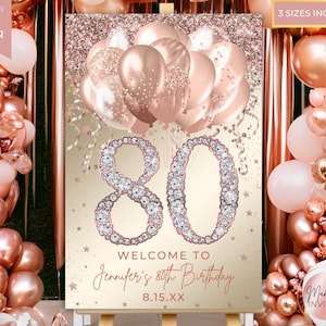 May include: A rose gold and gold sign for an 80th birthday celebration. The sign features the number 80 in a diamond-like design, with the text "Welcome to Jennifer's 80th Birthday" and the date 8.15.XX. Balloons and confetti are in the background.