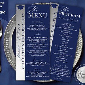 May include: Navy blue graduation menu and program cards with silver accents, displayed on a silver-rimmed plate with cutlery. The menu lists starters, main courses, desserts, and drinks. The program outlines the event's schedule.