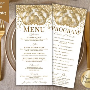 Op de afbeelding: Een menu- en programmakaartenset met een goud en wit ontwerp. Het menu bevat gerechten en het programma schetst de volgorde van de evenementen. De kaarten hebben gouden ballongraphics en liggen op een tafel met gouden bestek.