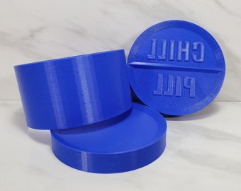 May include: Three blue plastic containers, one with the words "Pill" and "Chill" printed on it.