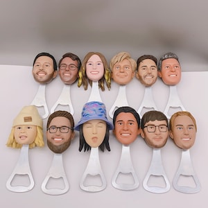 May include: A set of 12 bottle openers featuring different faces. Each opener is made of metal and has a silver finish. The faces are all different and have unique expressions.
