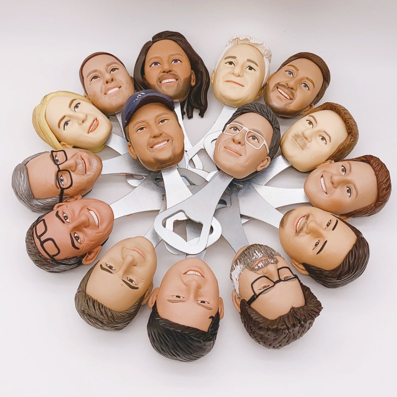 May include: A collection of 12 bottle openers, each featuring a different person's face. The bottle openers are made of metal and have a black finish. The faces are all different and unique, and they are all smiling. The bottle openers are arranged in a circle, and they are all facing the camera.