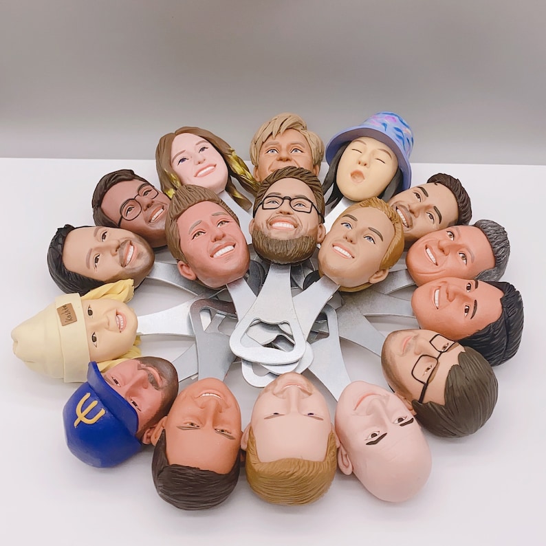 May include: A set of 15 bottle openers featuring different faces, including a variety of skin tones and hairstyles. The bottle openers are made of metal and have a silver finish.