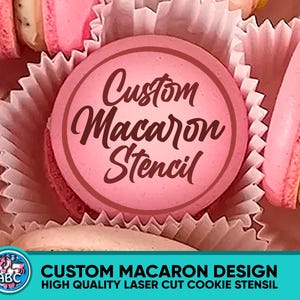 Puede incluir: Primer plano de macarons rosas en moldes de papel. Un círculo rosa con las palabras "Custom Macaron Stencil" está en el centro. La parte inferior de la imagen tiene el texto "CUSTOM MACARON DESIGN HIGH QUALITY LASER CUT COOKIE STENCIL".
