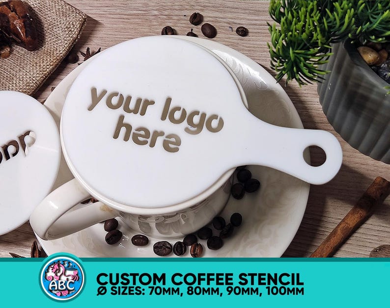 May include: White coffee stencil with a handle. The stencil has the text "your logo here" printed on it. The stencil is on a white saucer with coffee beans around it. The stencil is available in sizes 70mm, 80mm, 90mm, and 100mm.