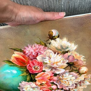 May include: A painting of a bouquet of pink, white, and orange flowers in a teal vase. The flowers are arranged in a loose, natural style, and the vase is sitting on a brown background.
