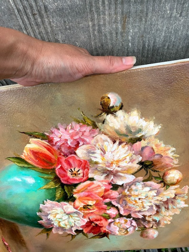 May include: A painting of a bouquet of pink, white, and orange flowers in a teal vase. The flowers are arranged in a loose, natural style, and the vase is sitting on a brown background.