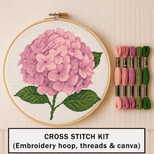 Pode incluir: Um kit de ponto cruz com um bastidor de madeira redondo contendo tecido branco com um desenho de hortênsia rosa. Estão incluídas cinco meadas de linha de bordar em tons de rosa claro, rosa escuro, roxo, verde claro e verde escuro.