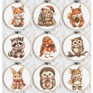 May include: Nine circular embroidery hoops featuring cross-stitch designs of woodland animals including a fox, bear, squirrel, raccoon, robin, owl, rabbit, hedgehog, and mouse, all wearing winter scarves and accessories on white fabric.