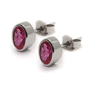 May include: A pair of silver stud earrings with oval-shaped pink gemstones.