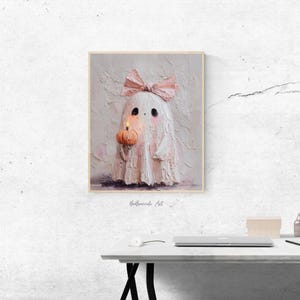 May include: A framed painting of a cute ghost holding a pumpkin with a lit candle. The ghost is white with a pink bow and blush. The artwork has a textured, impasto style and is signed "BeBreede Art".