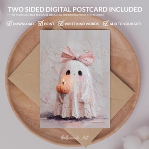 May include: A digital postcard featuring a cute ghost with a pink bow, holding a pumpkin with a lit candle. The postcard is on a wooden tray with a brown envelope. Text on the postcard reads "TWO SIDED DIGITAL POSTCARD INCLUDED".