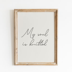 Peut inclure: Une impression encadr&eacute;e avec le texte "My soul is knitted" en &eacute;criture cursive. Le cadre est en bois clair et l'arri&egrave;re-plan est beige clair.
