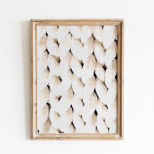 Peut inclure: Une impression d'art abstrait encadr&eacute;e avec un fond blanc et un motif de formes beiges et brunes. Le cadre est en bois clair.