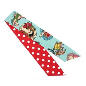 May include: A red and blue patterned fabric headband with white polka dots. The blue side features a design of a woman with a tattoo of a heart, a flower, and scissors. The text "Too Cool For School" is on the headband.