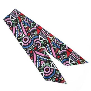 May include: A black fabric scarf with a geometric pattern in pink, red, blue, green, and yellow. The pattern features circles, triangles, and squares.