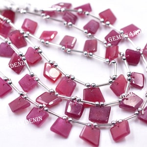 May include: A strand of pink gemstone beads with silver spacers. The beads are square shaped and have a faceted finish. The strand is approximately 18 inches long.