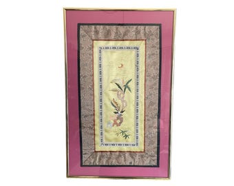 May include: A framed embroidered artwork with a yellow background and a floral design in shades of pink, green, and white. The artwork is surrounded by a multi-layered frame with a pink outer layer, a black inner layer, and a brown patterned layer.