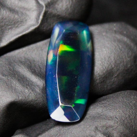 Faceted Black Opal: Red Fire Cushion Cut Gemstone (3.88 Carats, 21x9x4 mm