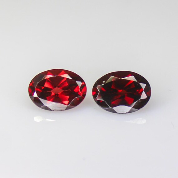 Faceted Red Garnet Pair: 2.55 Carats, 7x5mm Oval Gemstones