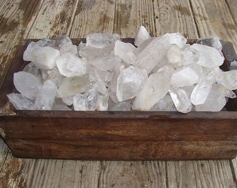 May include: A wooden box filled with a large quantity of clear quartz crystals.
