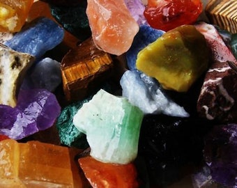 May include: A collection of colorful, rough-cut gemstones, including amethyst, tiger's eye, and green aventurine.