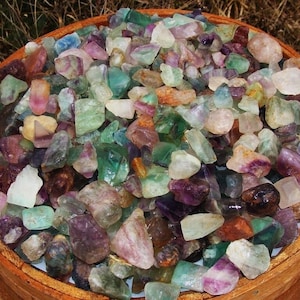 May include: A large bowl filled with a variety of colorful fluorite crystals. The crystals are various shades of green, purple, and pink.
