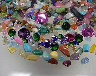 May include: A collection of colourful gemstones and tumbled stones, including amethyst, turquoise, and green aventurine. The stones are arranged in a random pattern on a white surface.