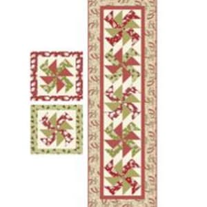 May include: A quilted table runner and two matching placemats. The runner and placemats feature a pinwheel design in red, green, and cream colors. The runner is rectangular, and the placemats are square.