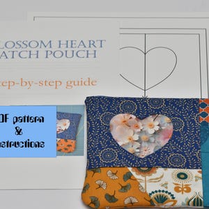 May include: A PDF pattern and instructions for a patchwork heart-shaped pouch. The pouch is made of blue, orange, and white fabric with a floral heart cutout. The instructions include a step-by-step guide and a template for the pouch.