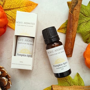 May include: A 10ml bottle of Pumpkin Spice essential oil blend and its box, both labelled with "Nicki's Aromatics, Scents for the Senses." The amber glass bottle sits among autumn leaves and cinnamon sticks. The box and bottle are 10ml.