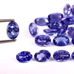 Puede incluir: Un grupo de piedras preciosas azules de forma ovalada y facetadas. Las piedras preciosas est&aacute;n dispuestas en una fila, con la piedra preciosa m&aacute;s grande en el centro. Las piedras preciosas est&aacute;n colocadas sobre un fondo blanco.
