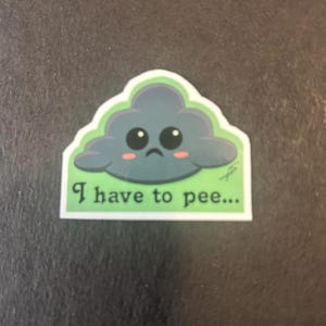 May include: A green and gray sticker with a cartoon cloud with a sad face and the text "I have to pee..."